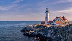 Portland Head Light standing on rocky cliffs above the Atlantic at dusk