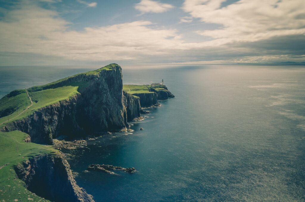 Grassy clifftop headland reaching out into a silver sea