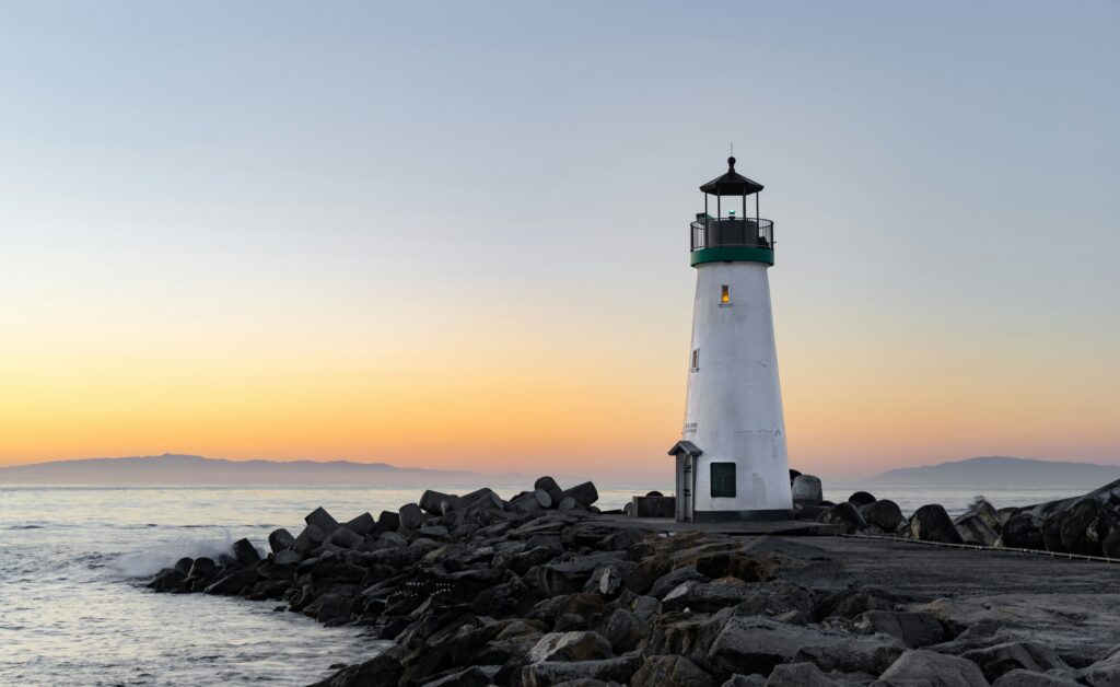 Walton Lighthouse at the end of a rock breakwater at sunrise