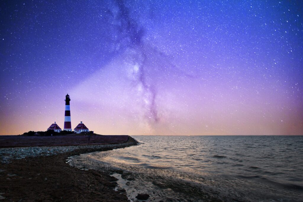 Lighthouse and keeper's houses beneath the Milky Way at night