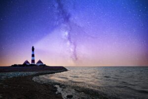 Lighthouse and keeper's houses beneath the Milky Way at night